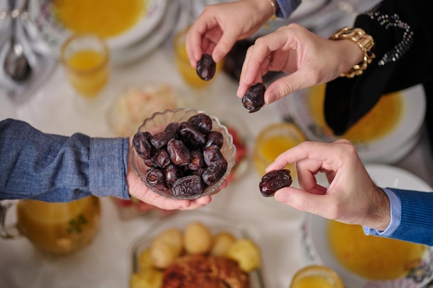 Photo happy muslim family having iftar dinner to break fasting during ramadan dining table at home