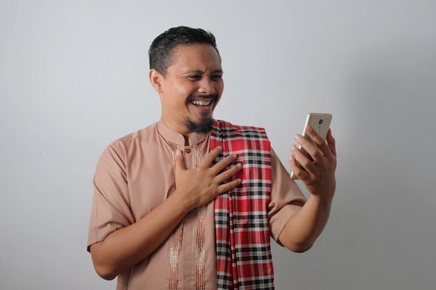 Happy muslim man looking phone screen