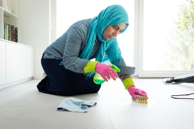 Happy Muslim Woman Cleaning Modern House Living Room. High quality photo