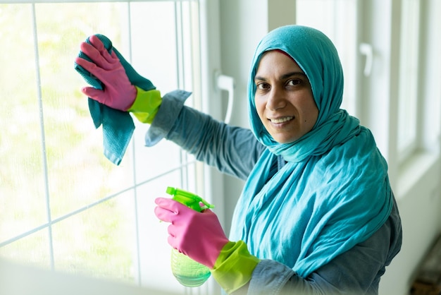 Happy Muslim Woman Cleaning Modern House Living Room. High quality photo