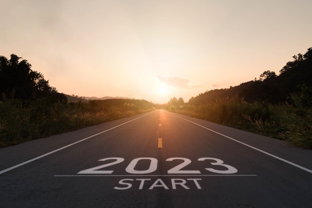 Happy new year 20232023 symbolizes the start of the new year The letter start new year 2023 on the road in the nature route roadway sunset have tree environment ecology or greenery wallpaper concept