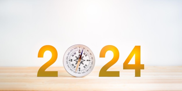 Happy New Year 2024 and business direction concept 2024 year number decoration with white modern round compass on wooden table and white background Focus searching and start a new year change