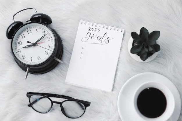 Happy New Year concept. The notebook with 2023 goals text on white fur background.