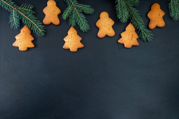 Happy New Year's set of gingerbread from ginger biscuits man glazed sugar icing decoration on black background, minimal seasonal pandemic winter holiday banner