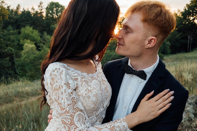 Happy newlyweds kissing at sunset, close-up, portrait