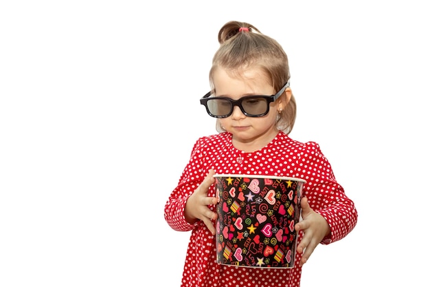 Happy nice girl in 3D glasses watching movie and eating popcorn isolated over white background