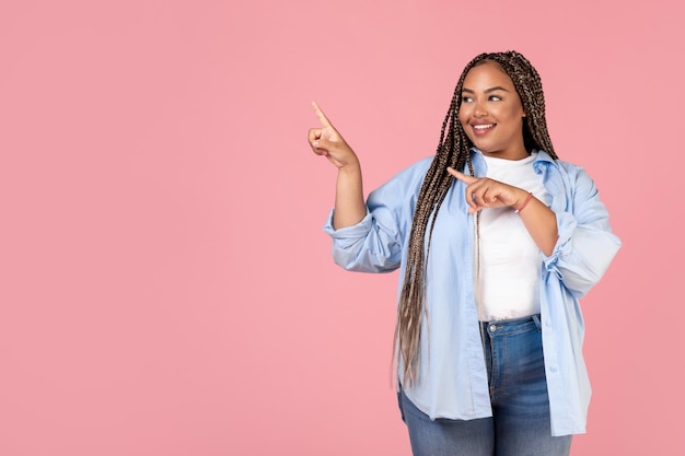 Happy Obese Black Woman Pointing Fingers Aside Over Pink Background