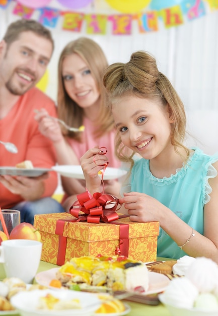 Happy  parents and daughter  with cake at birthday party