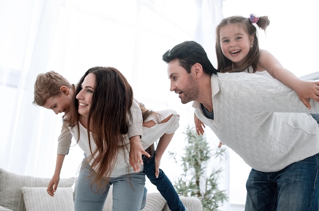 Happy parents play with children at homephoto with copy space