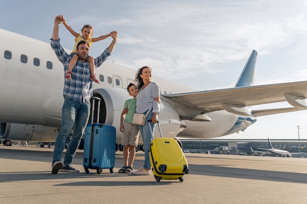 Happy parents and their children waiting to travel together