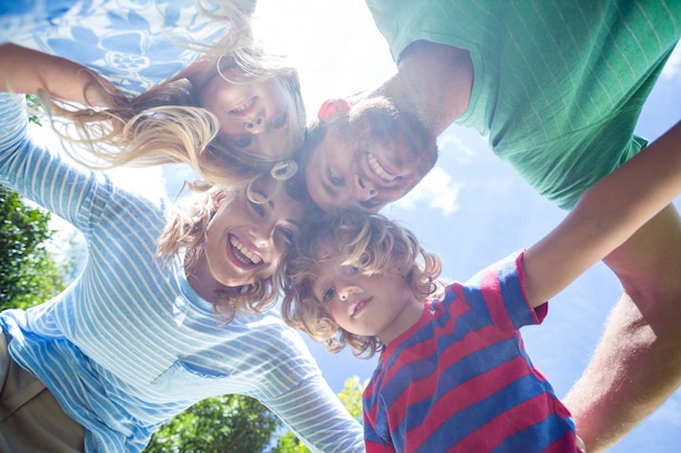 Happy parents with children forming huddle at yard