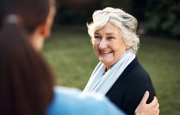 Happy park or old woman with caregiver in retirement speaking with empathy compassion or affection