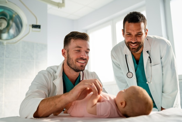 Happy pediatrician doctor examines baby. Healthcare, people, examination concept