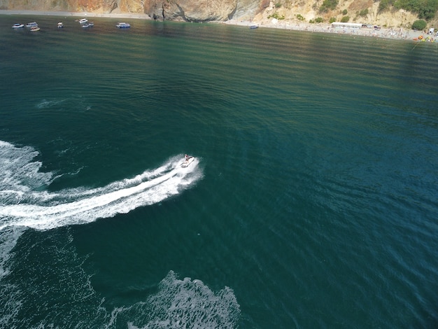 Happy people are going to swim on an air mattress behind a jet ski tourists ride the inflatable