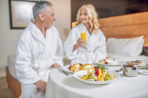 Happy people. Couple in bath robes enjoyong their time together and looking happy