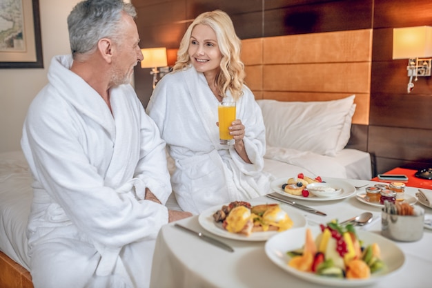 Happy people. Couple in bath robes enjoyong their time together and looking happy