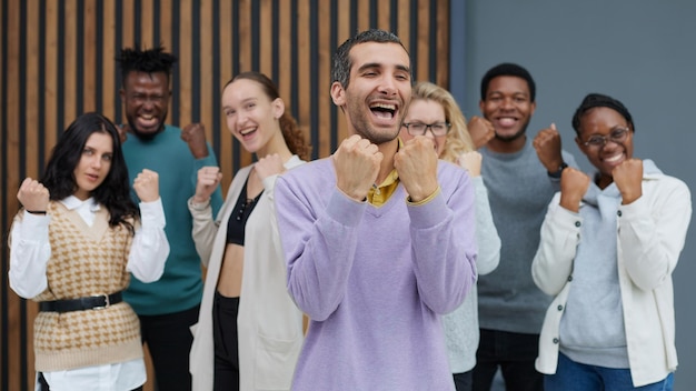 Happy people raise their hands up clenching their fists