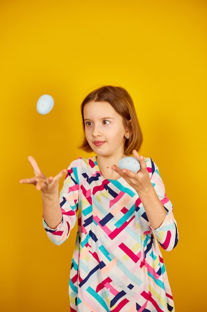 Happy playful teenager girl with painted Easter eggs