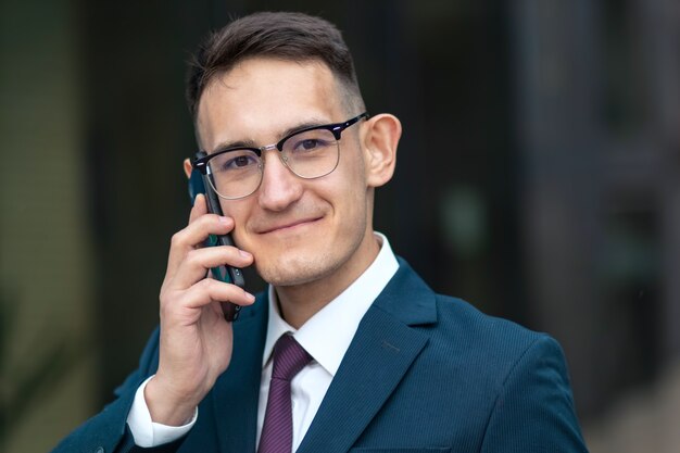 Happy positive businessman talking on phone