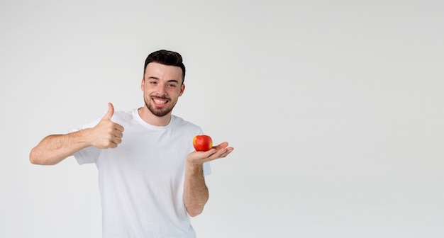 Happy positive cheerful guy hold apple on hand