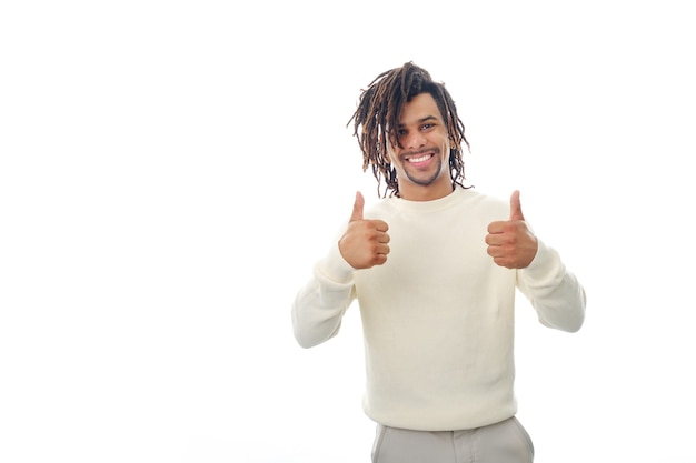 Happy and positive latin man showing thumbs up to the camera while standing on an isolated background.