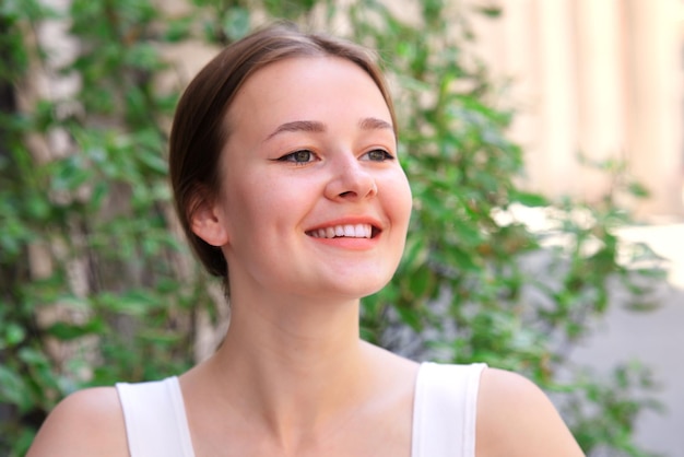 happy positive smiling girl young beautiful woman outdoors on green tree background at summer day