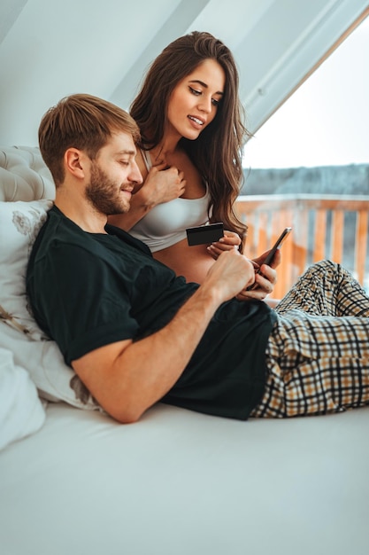 Happy pregnant female with her husband shopping online