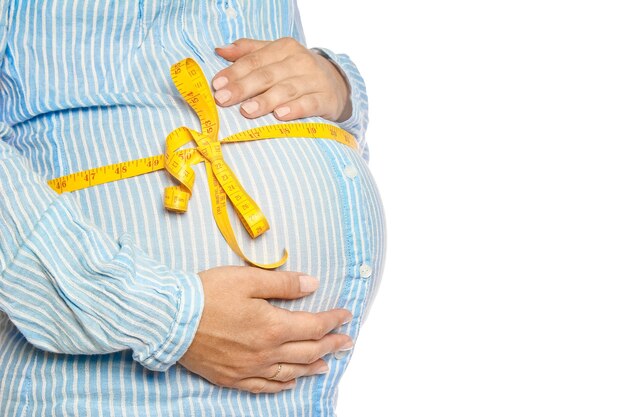 Happy pregnant girl lies on white wall