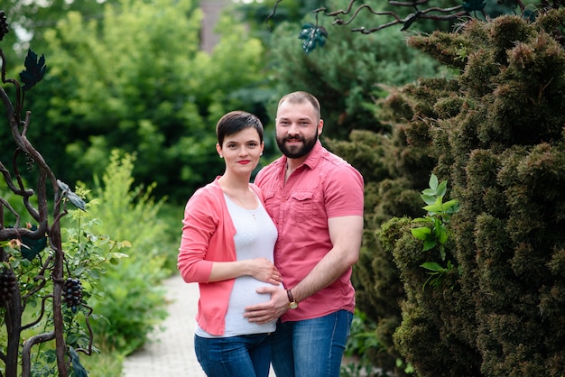 Happy pregnant woman and her husband in the park