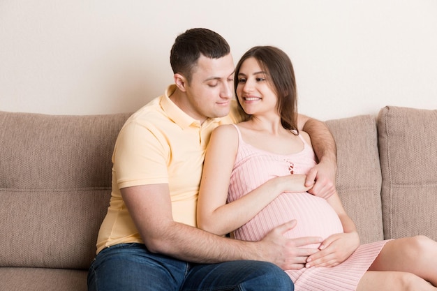 Happy pregnant woman and her husband waiting for baby at the home happy family love and care concept