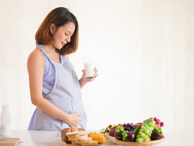 Happy pregnant women drink milk, healthy nutrition during pregnancy