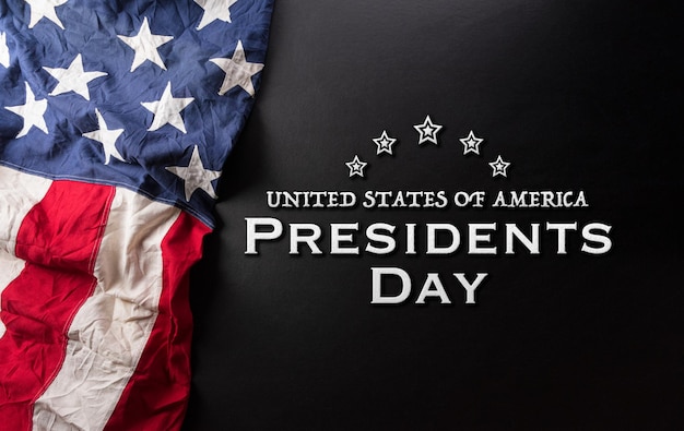 Happy presidents day concept with flag of the United States and the text on dark  background.