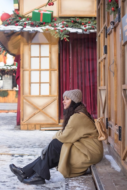 Happy pretty girl during Christmas holidays in a festive town at a Christmas market