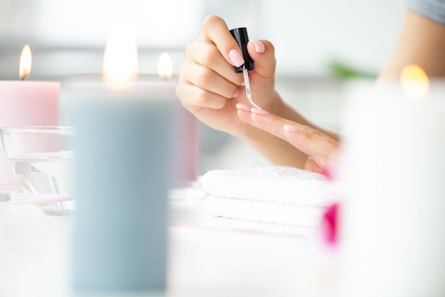 Happy pretty woman making manicure in her bathroom