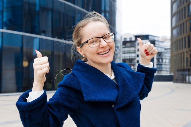 Photo happy professional posing near office building caucasian business woman