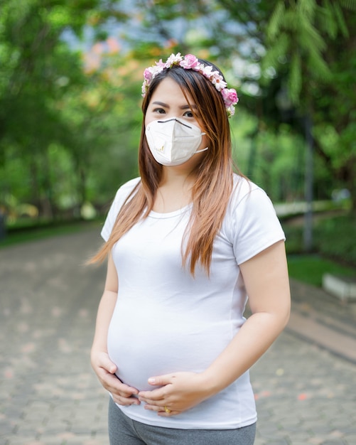 Happy and proud pregnant woman with mask