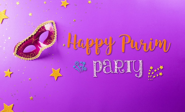 Happy Purim carnival decoration concept made from mask and sparkle star on purple background Happy Purim in Hebrew jewish holiday celebrate