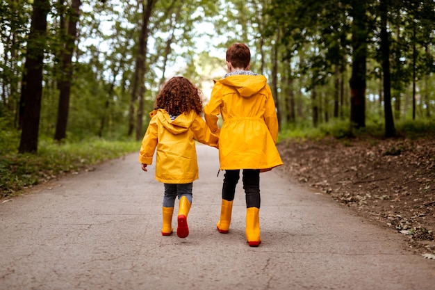 Happy redhead boy and girl in raincoats