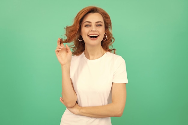 Happy redhead woman with curly hair on blue background joy