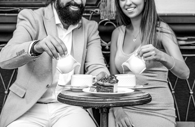 Happy romantic couple sitting in a cafe drinking coffee Young couple drinking cappuccino at bar coffee shop Black and white