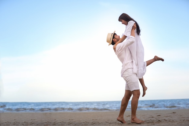 Happy Romantic Couples lover holding hands together walking on the beach