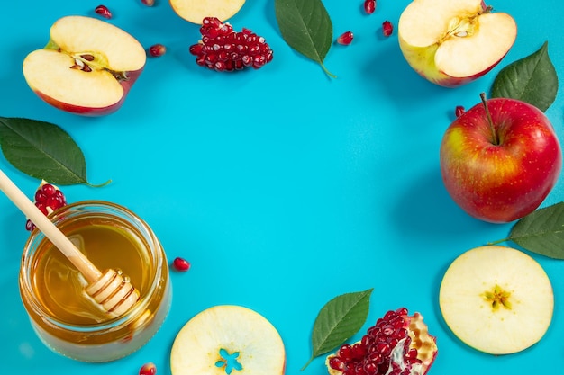 Happy Rosh Hashanah Honey apples and pomegranates on blue background Round frame for your text Jewish traditional religious holiday