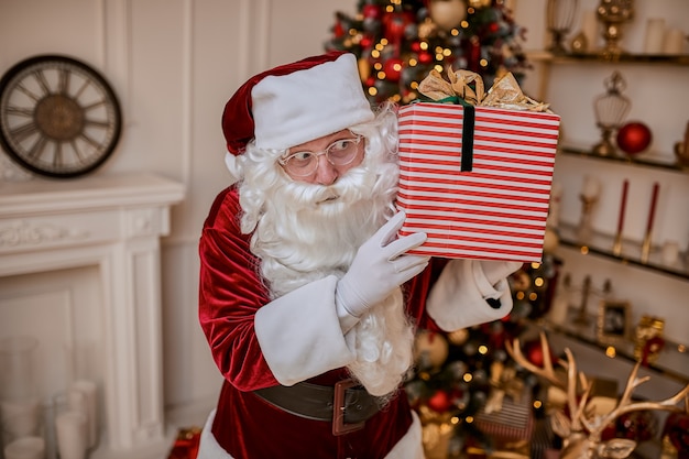 Photo happy santa claus brought gifts to children.  new year and merry christmas holidays concept