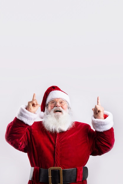 Happy Santa Claus, pointing up in white wall