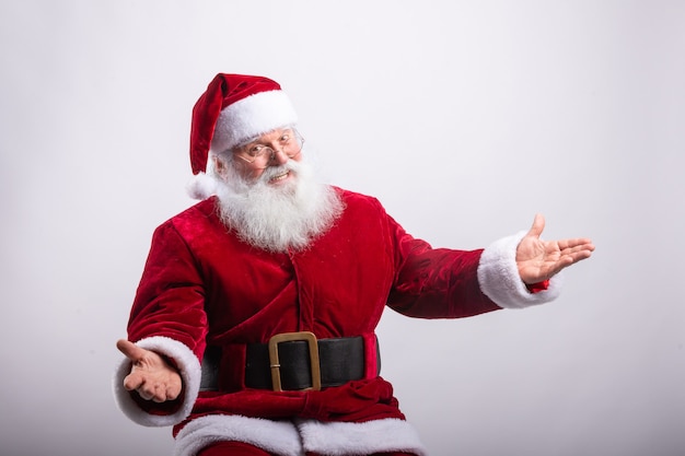 Happy Santa Claus, sat with arms open in white wall