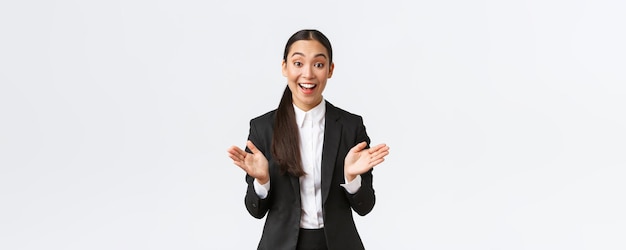 Happy satisfied asian female businesswoman react to great news raising hands up applausing and congr