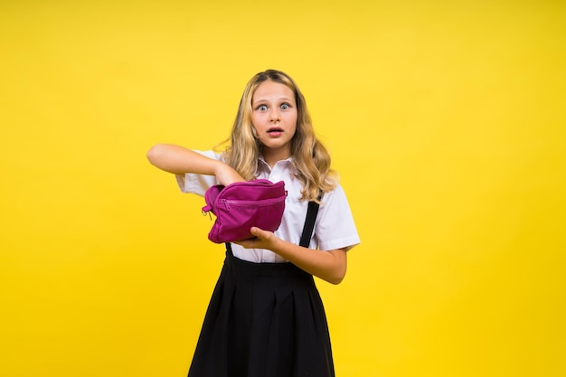 Happy schoolgirl with colored pencils and a pencil case in hand