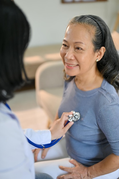 Happy senior Asian woman is having her heart and lungs checked by a doctor at the hospital