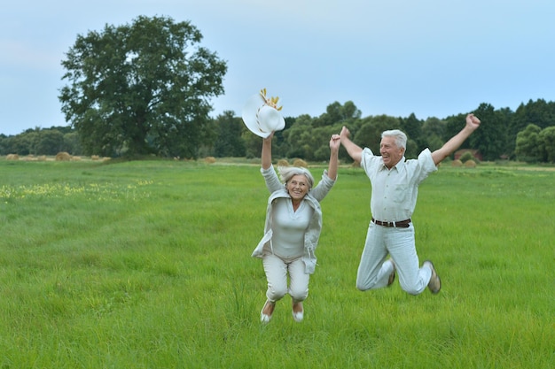 Happy senior couple jumping on a summer day