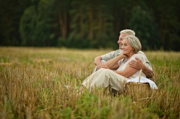 Happy senior couple on mowed field of wheat